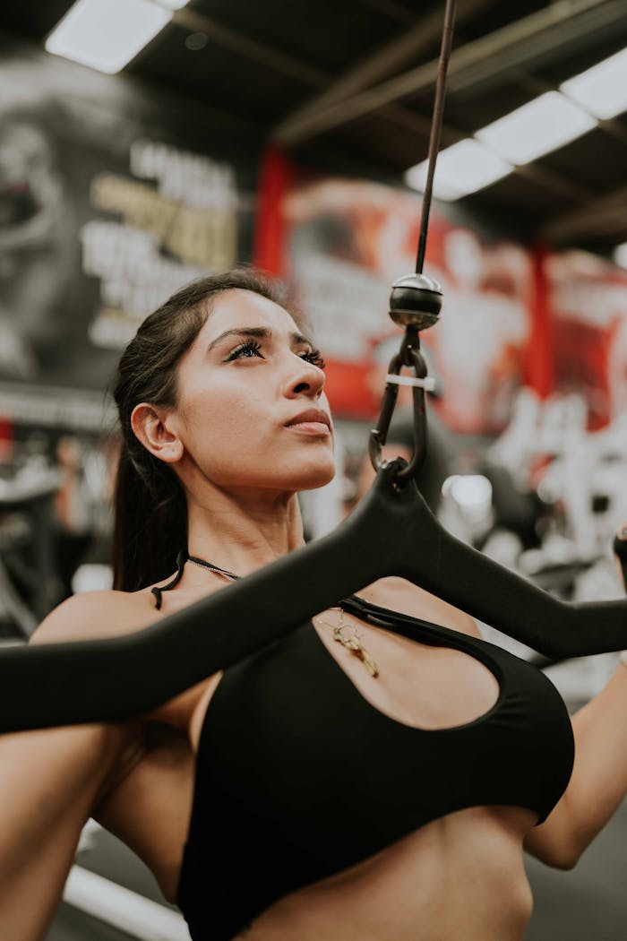 Portrait of a determined woman working out in a gym using fitness equipment.